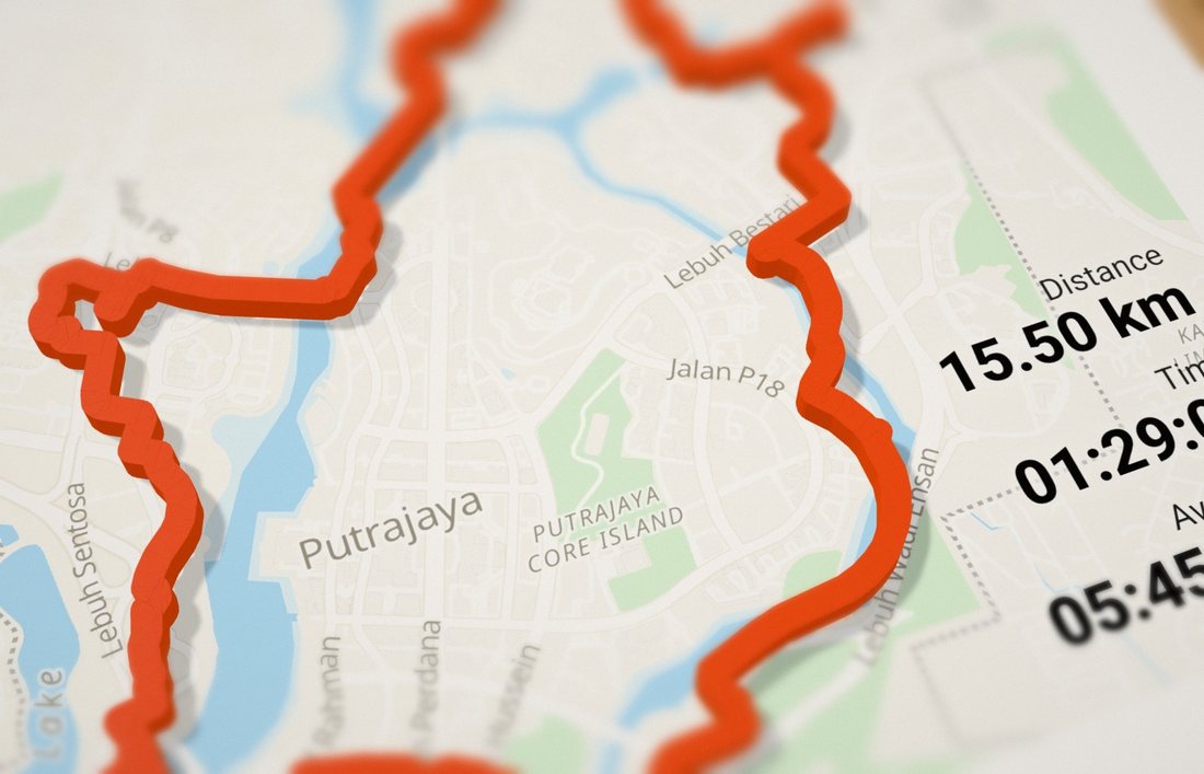 Raised orange route on a printed map, seen from above at an angle